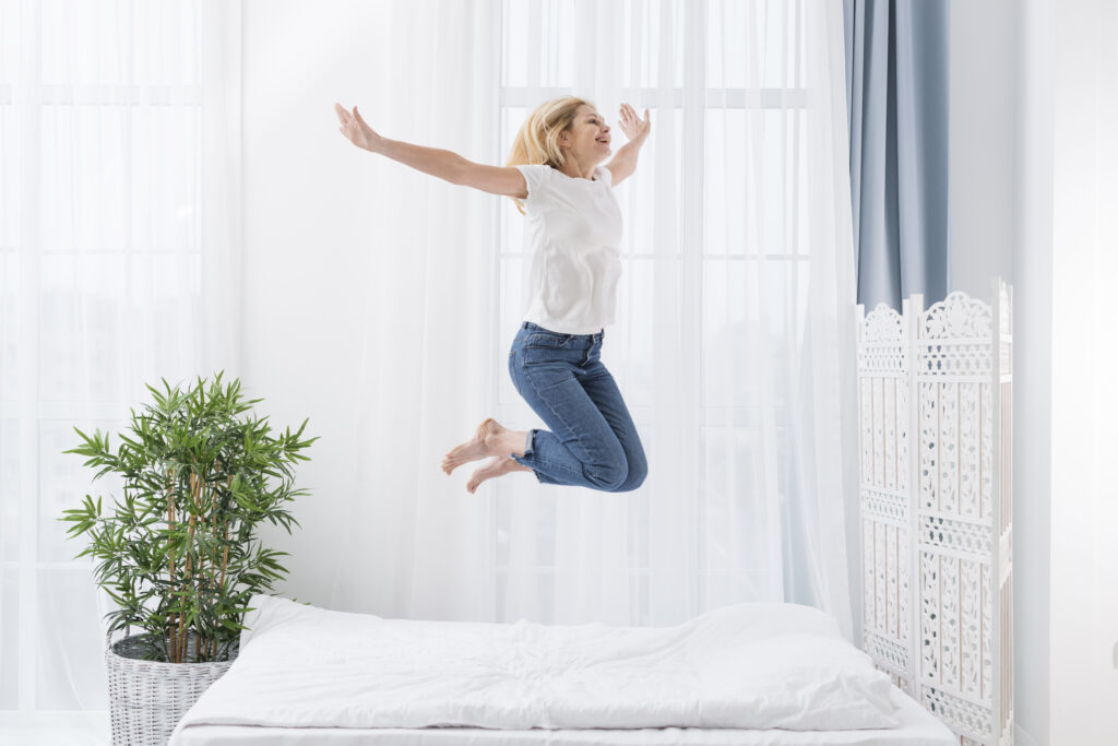 Portrait Happy Woman Jumping Bed 1024x683
